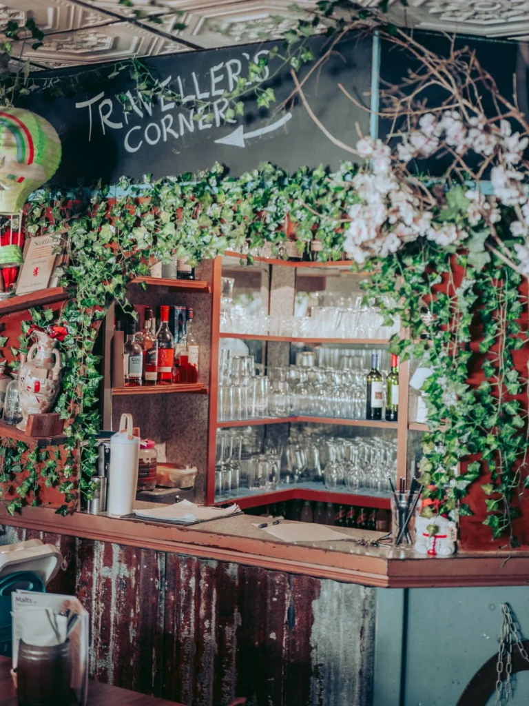 Bar corner decorated with artificial plants and bottles, rustic atmosphere and travel in a restaurant in Fort William in the Scottish Highlands in August 2026.