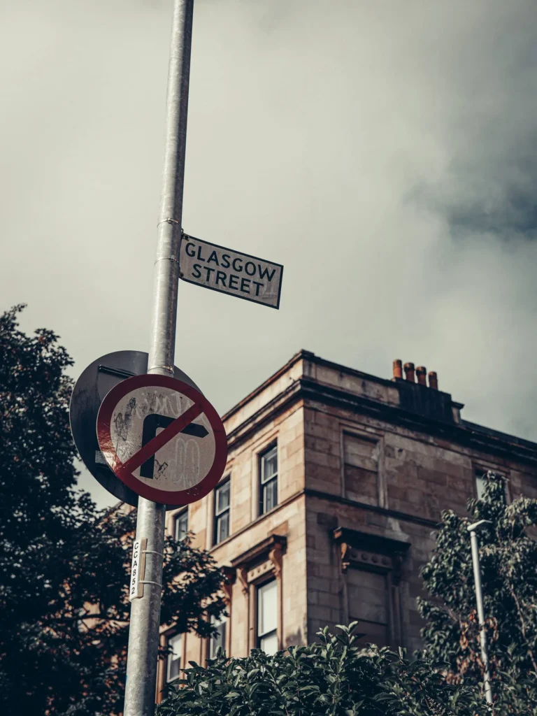 Glasgow Street sign and no entry sign in front of a sandstone building in the West End, on the way to the University of Glasgow.