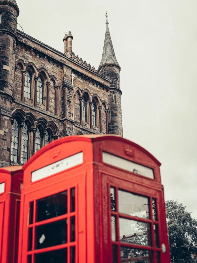 The Main Building of the University of Glasgow and its tower behind the alignment of red telephone boxes. The neo-Gothic ensemble was designed by George Gilbert Scott at the end of the 19th century.