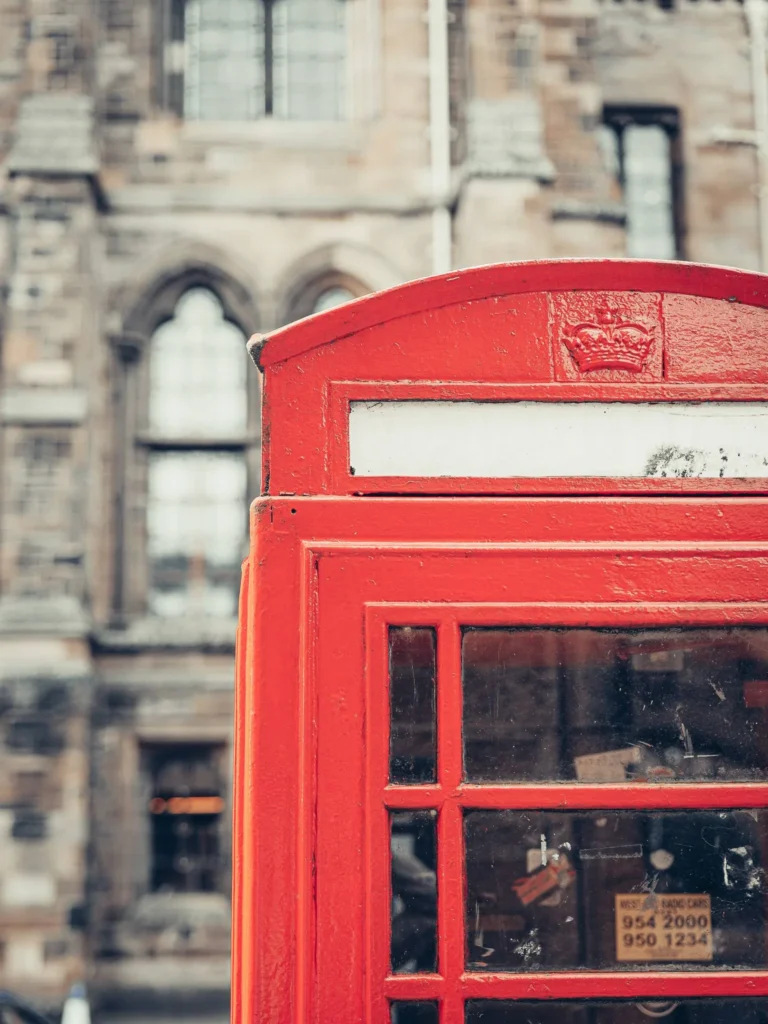 Red telephone box in front of the neo-Gothic facade of the University of Glasgow, in the West End.