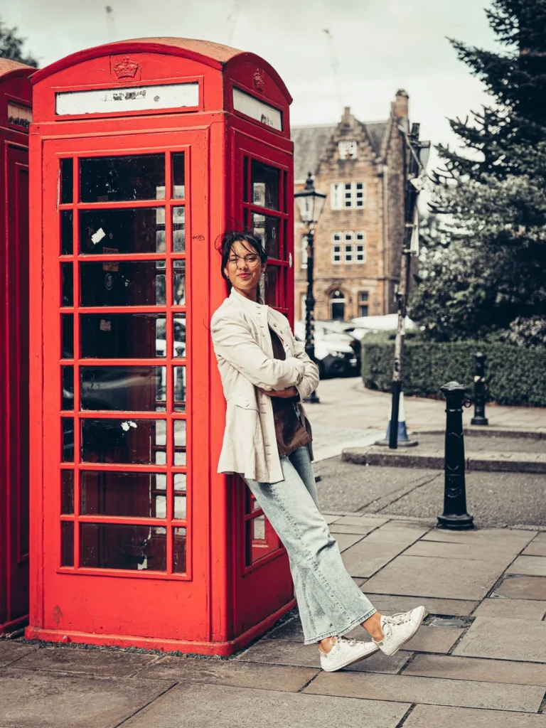 Caroline in front of a red phone box, the neo-Gothic architecture of the University of Glasgow in the background.