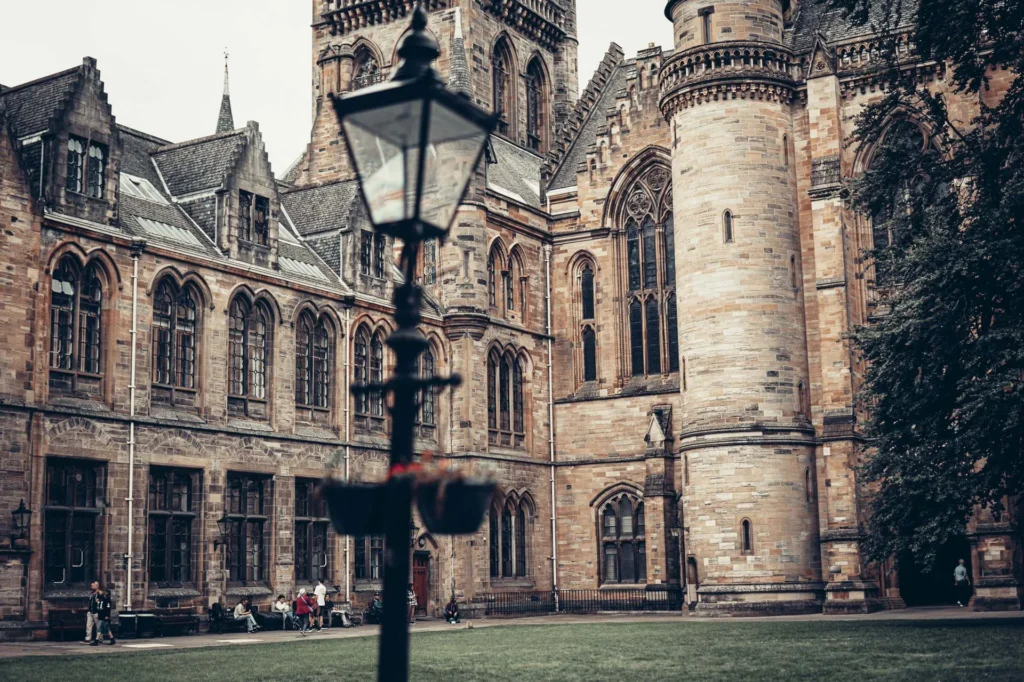 Facade of the University of Glasgow seen from a quadrangle, with its arches and its tower, in the West End.