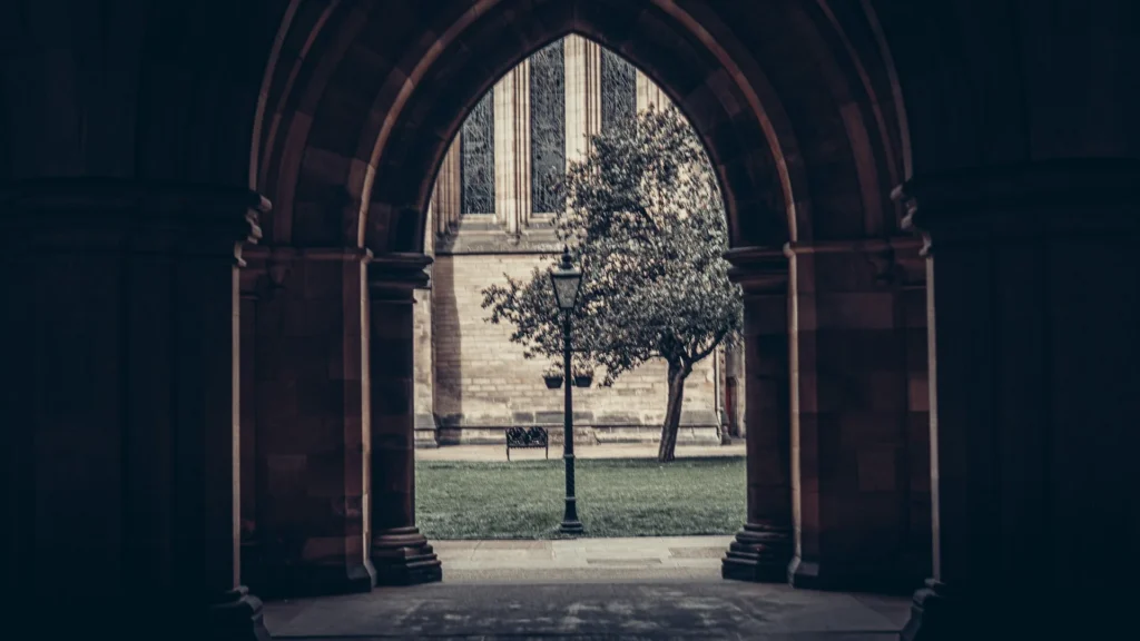 The view from the Cloisters at the University of Glasgow onto the quadrangle, its tree, its bench and its lamp post.