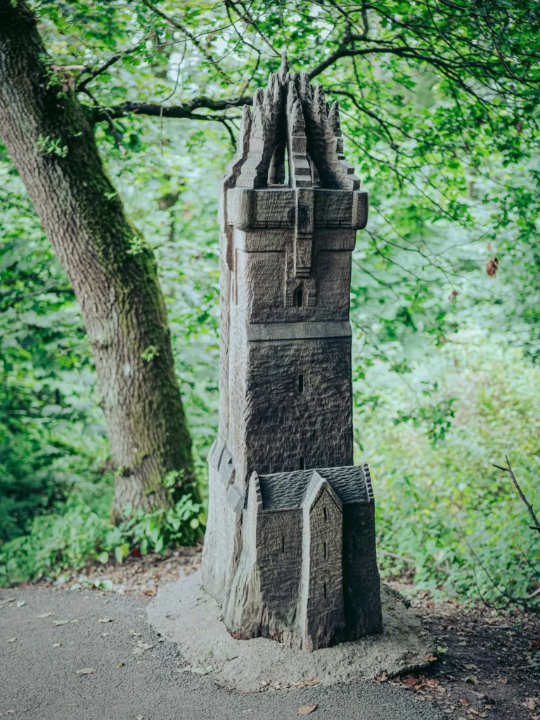 Wooden carving of the Wallace Monument itself, on the wooded Wallace Way path near Stirling, Scotland, August 2026.