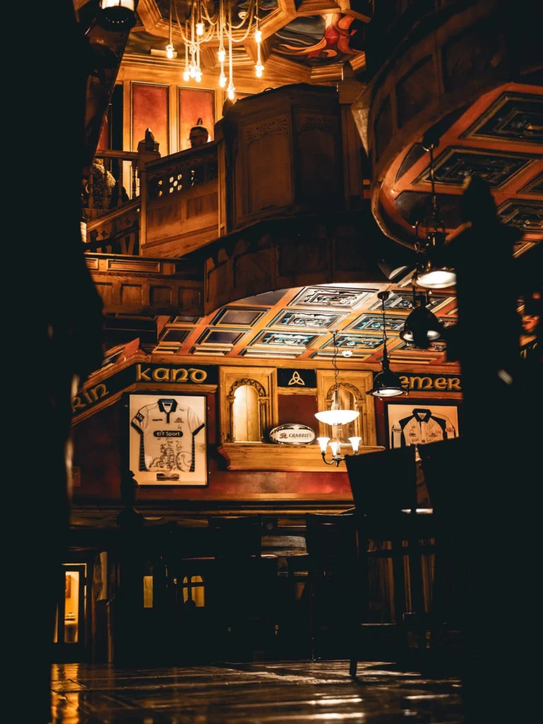 Dark, wooden room of the Waxy O'Connor's pub in Glasgow, chandeliers and carved panels
