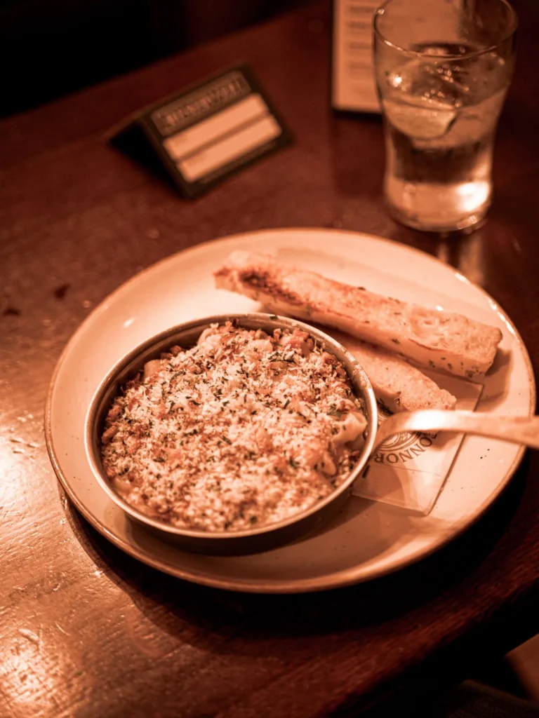 Guinness mac and cheese with a browned top, served with garlic bread at Waxy O'Connor's in Glasgow.