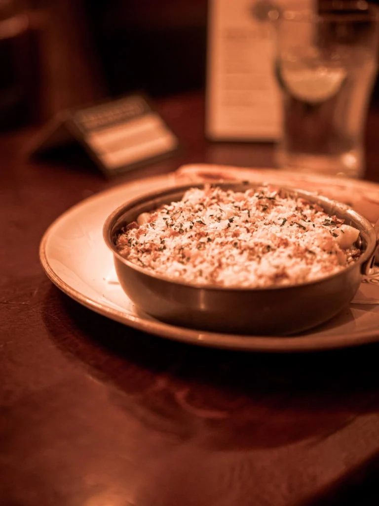 Guinness mac and cheese with a browned top on a wooden table at Waxy O'Connor's pub in Glasgow.
