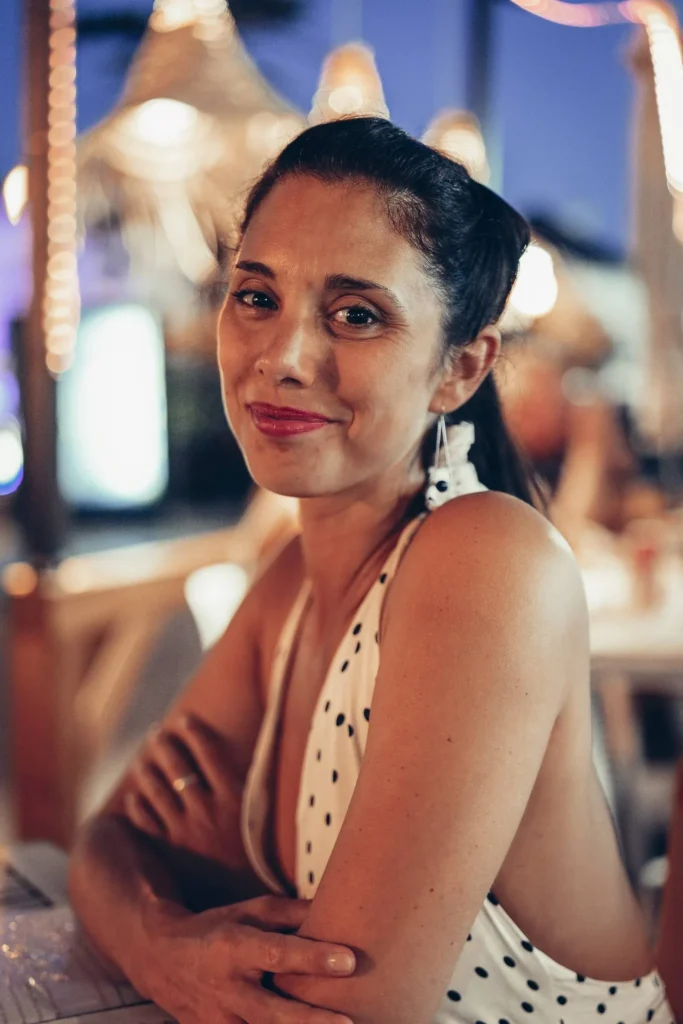 Caroline sitting at a table in a cozy restaurant, in the evening in Tavira, Algarve.