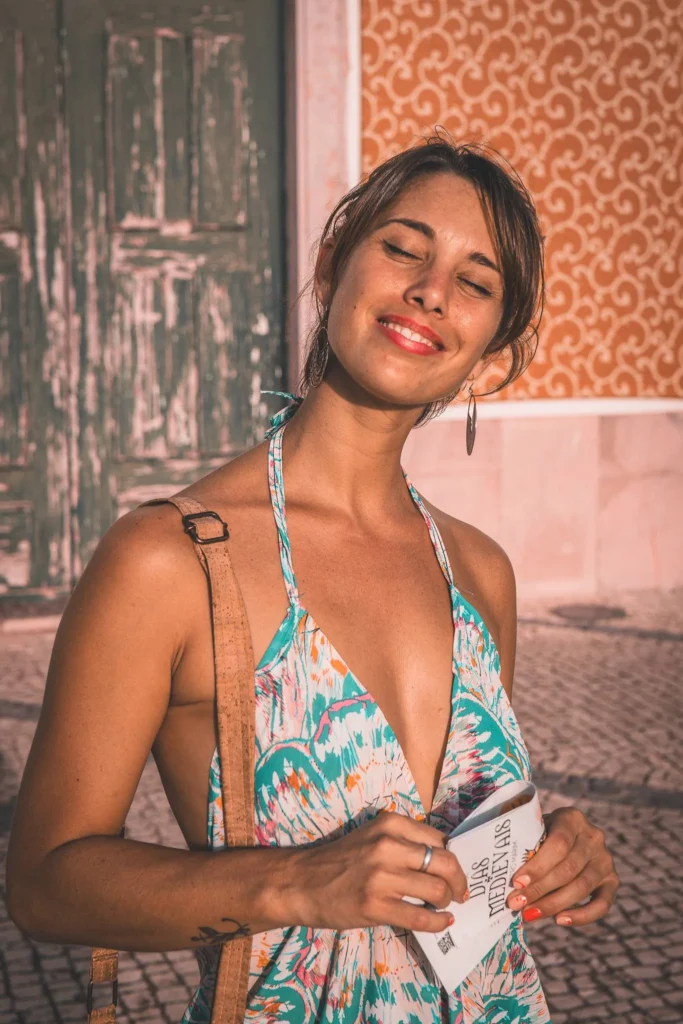 Caroline poses in a floral dress in front of a decorative facade building in Castro Marim, under summer light.