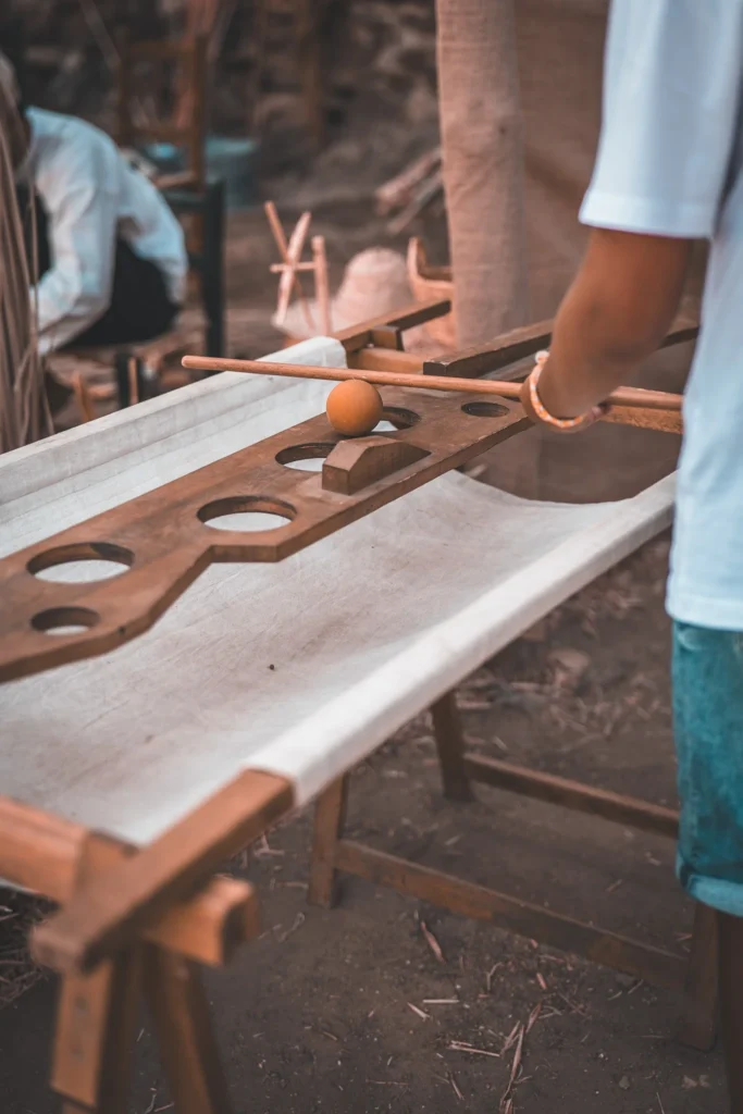 Traditional wooden game on a table during an outdoor activity, someone playing. Craft and medieval atmosphere.