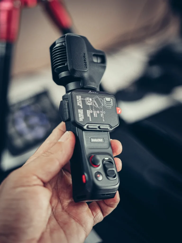 Insta360 Luna Pro held in hand, still equipped with its instruction stickers